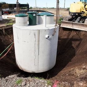 Environmentally friendly septic tank being lowered into ground.  More building a home:-