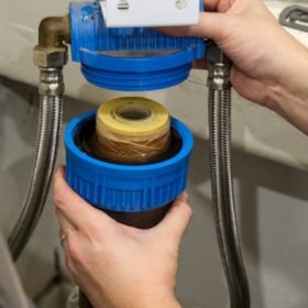 Replacement of a water softener filter cartridge by a technician, in a house.